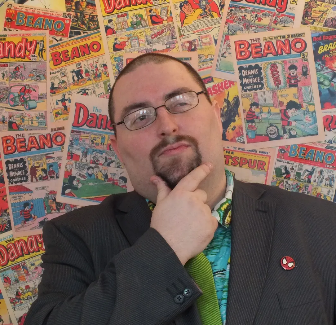Chris Murray in front of a wall of comics