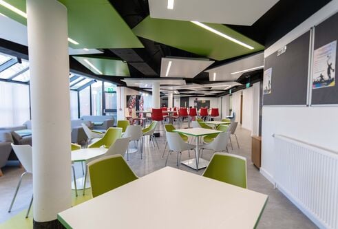Green and red tables and chairs in dining room