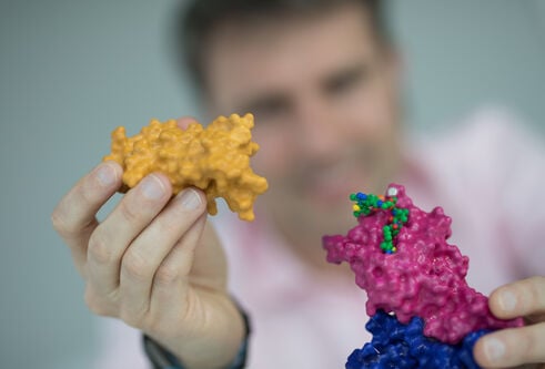 man, blurry, holding a model, in focus