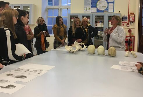 a group of school pupils standing around  table  getting a lesson in anatomy