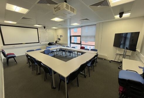 Dalhousie 2S02 - tables and chairs with a mobile tv screen and white screen at far wall