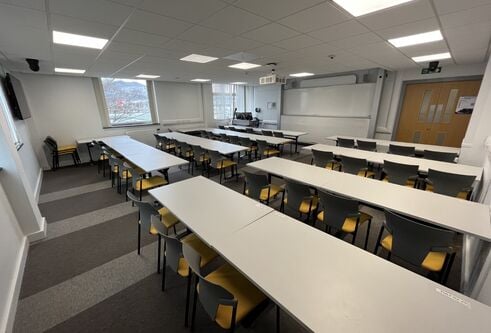 Fulton room showing white tables and a large white screen