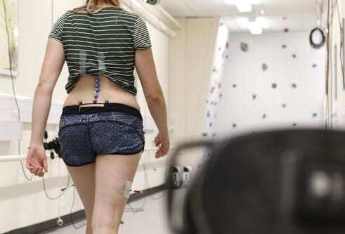 Lady walking with motion sensors to study movement. 