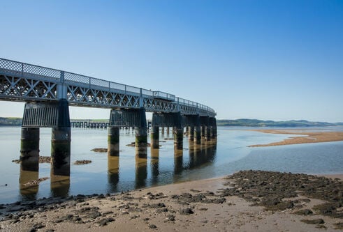 rail bridge stretching out across the river on a sunny day