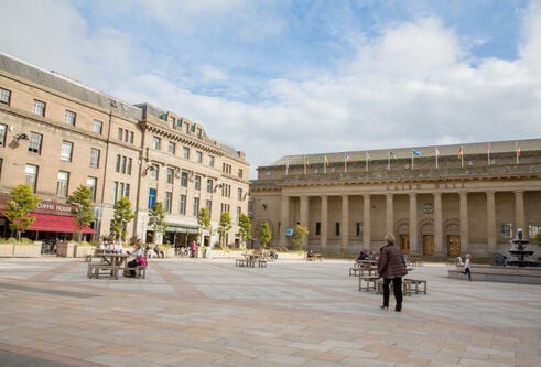 building with pillars in front of it opening out on to a square with buildings to the side