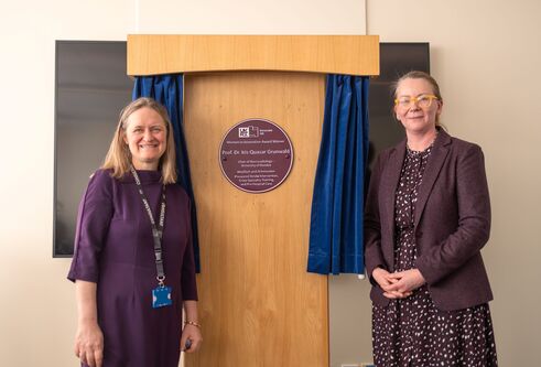  Prof Grunwald and Janet Geddes stand either side of the Purple Plaque presented to Professor Grunwald