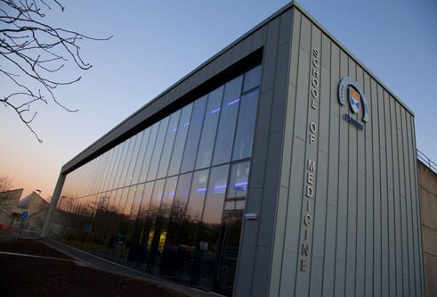 The exterior of the School of Medicine library at sunset