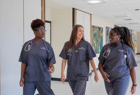 Three medical students wearing scrubs at the University of Dundee School of Medicine