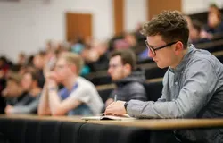 Student taking notes during a lecture