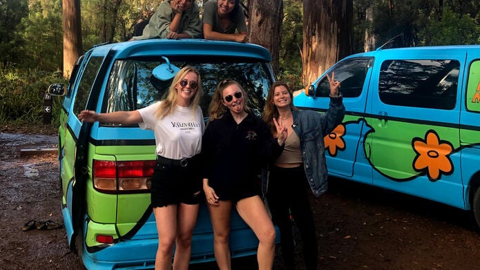 Students on study exchange posing outside van