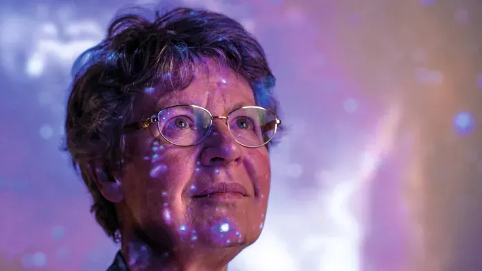 Professor Dame Jocelyn Bell Burnell with image of a galaxy
