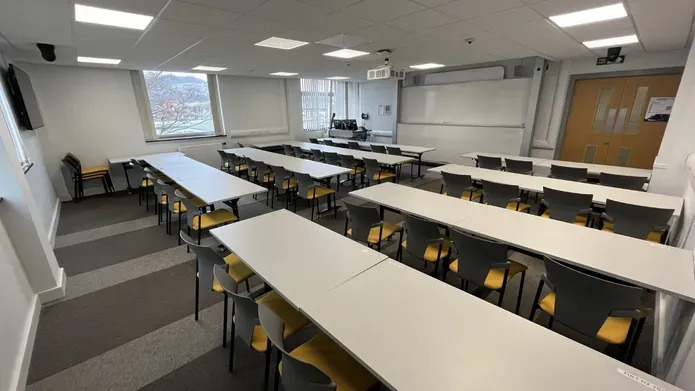 Fulton room showing white tables and a large white screen
