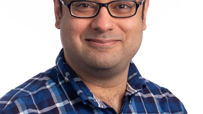 man in glasses wearing blue checked shirt