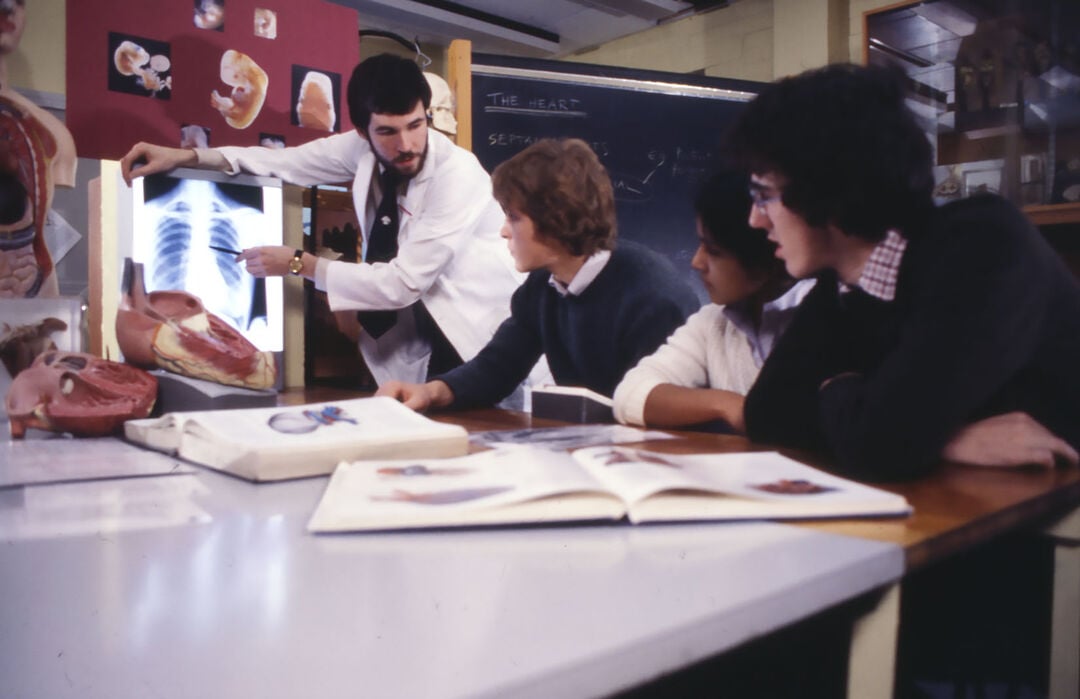 Old photo of classroom teacher and students showing xray and books
