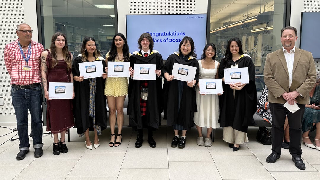 A group of people standing together smiling holding prize certificates